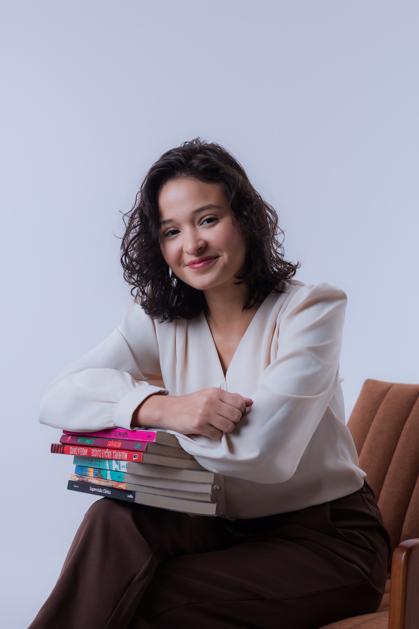 Michelle apoiada sobre uma pilha de livros